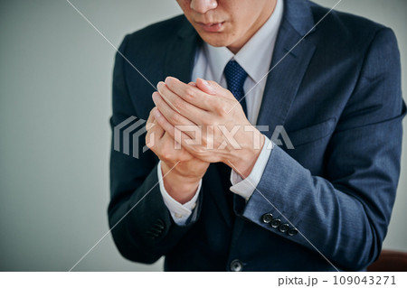 手先が冷える末端冷え性の男性会社員 109043271