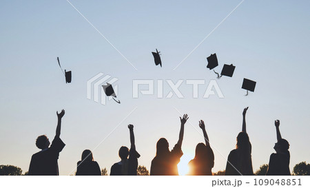 Silhouettes of Happy college graduates tossing their caps up at sunset. Silhouettes of Happy college graduates tossing their caps up at sunset. 109048851