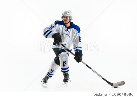 Young man, hockey athlete in motion, standing on rink with stick, training, playing against white studio background 109049096