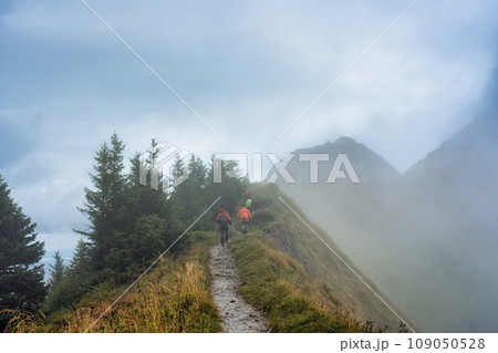 Group of backpacker walking on trail in foggy mountain on the morning at Switzerland Group of backpacker walking on trail in foggy mountain on the morning at Switzerland 109050528