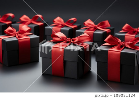 Red Gift Boxes with Black Ribbon and Bow on Black Background. Black Friday Concept 109051124