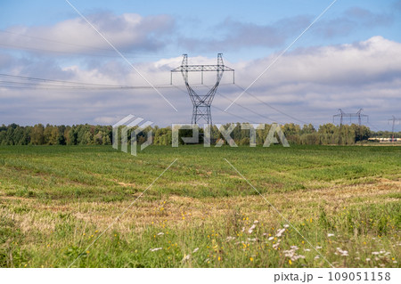 Metal poles electric supports for high-voltage wires in the fields in the summer.High Voltage Poles or Electric tower is transmission high voltage power locate on green field Energy technology concept 109051158