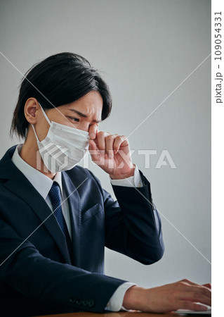 目がかゆくて指で擦る若い男性会社員 目がかゆくて指で擦る若い男性会社員 109054331