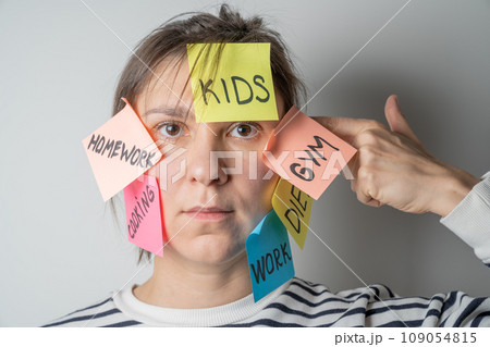 Mental load concept - female has post-it notes with social responcibilities on her face 109054815