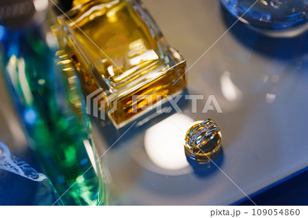 Two beautiful gold wedding rings and a bottle of perfume. Two beautiful gold wedding rings and a bottle of perfume. 109054860