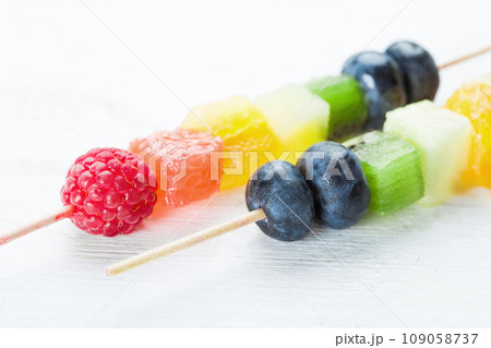 Kebab with raspberries, kiwi, orange and other fruits on the plate 109058737