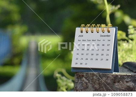 December 2024 calendar with green blurred background of hanging bridge. December 2024 calendar with green blurred background of hanging bridge. 109058873