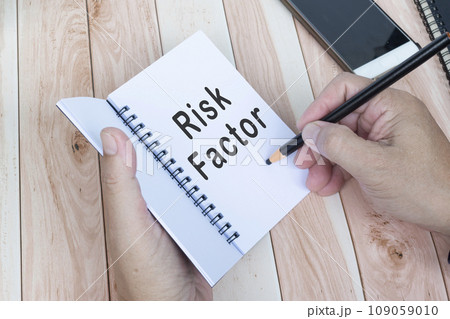 Businessman hands with pen writing notebook on office desk. Risk Factor. 109059010