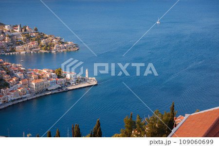 Symi Island, Greece. Greece islands holidays from Rhodos in Aegean Sea. Colorful neoclassical houses in bay of Symi. view of main bay of island, where tourist ferries and yachts moor Symi Island, Greece. Greece islands holidays from Rhodos in Aegean Sea. Colorful neoclassical houses in bay of Symi. view of main bay of island, where tourist ferries and yachts moor 109060699