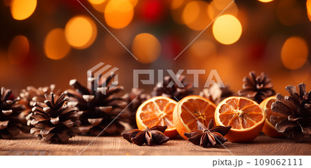 Traditional Christmas spices and dried orange slices on holiday bokeh background with defocus lights Traditional Christmas spices and dried orange slices on holiday bokeh background with defocus lights 109062111
