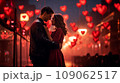 Beautiful young couple kissing in winter weather outdoors, enjoying spending time together while celebrating Saint Valentine's Day and air balloons in shape of heart on the background.  109062517
