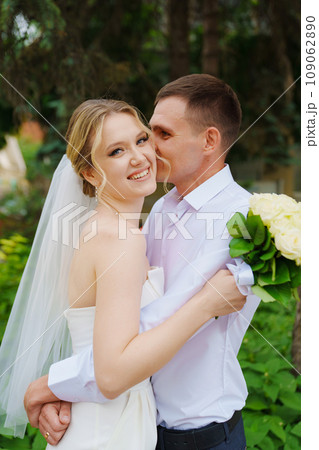 Gentle and happy newlyweds on a walk in the park. Gentle and happy newlyweds on a walk in the park. 109062890