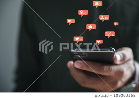 Dynamic connection between social mediand communication unfolds as man uses his smartphone to type in live chat. Chat box icons symbolize digital essence of social network and chatting concepts. 109063368