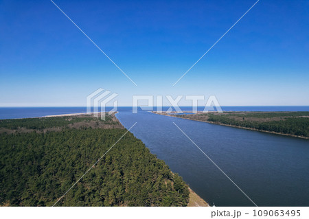 Aerial view drone of river goes into the sea. Delta of Vistula river goes in Baltic Sea in Sobieszewo Gdansk Poland. Forest and small village around Aerial view drone of river goes into the sea. Delta of Vistula river goes in Baltic Sea in Sobieszewo Gdansk Poland. Forest and small village around 109063495