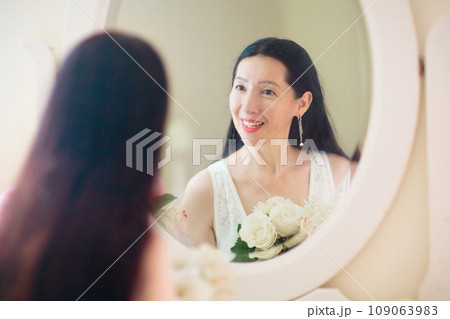 Young Asian woman looking in the mirror. Young Asian woman looking in the mirror. 109063983