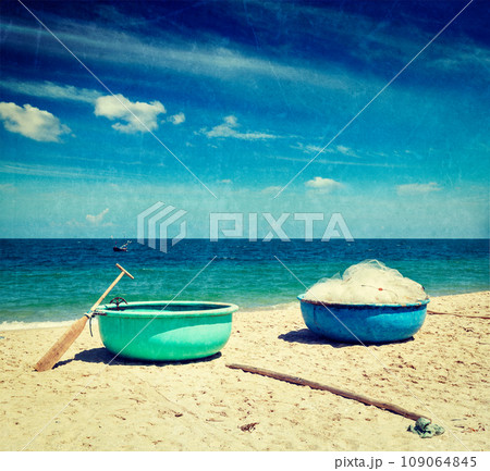 Vintage retro hipster style travel image of fishing coracle boats on beach with grunge texture overlaid. Mui Ne, Vietnam 109064845
