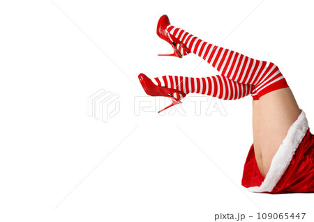 Sexy Santa woman legs in red shoes and striped socks 109065447