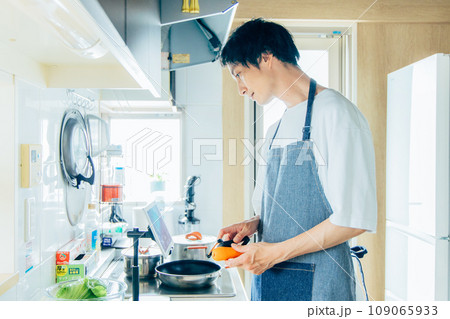 キッチンで料理をする男性 109065933