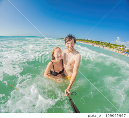 Amidst the tranquil turquoise sea, a pregnant woman and her husband share a serene moment, celebrating the beauty of impending parenthood in the gentle waves Amidst the tranquil turquoise sea, a pregnant woman and her husband share a serene moment, celebrating the beauty of impending parenthood in the gentle waves 109065967