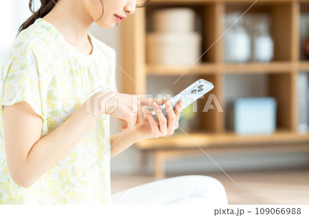 スマホをチェックする女性。（パーツ） 109066988