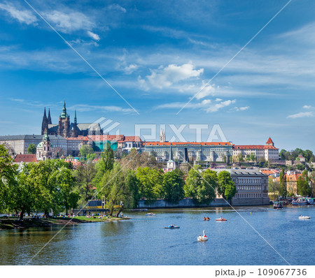 Panorama view of Vltava river and Gradchany (Prague Castle) and St. Vitus Cathedral and Charles bridge an people in paddle boats in the Prague, Czech Republic Panorama view of Vltava river and Gradchany (Prague Castle) and St. Vitus Cathedral and Charles bridge an people in paddle boats in the Prague, Czech Republic 109067736