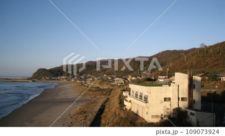 初冬の澄んだ青空と日本海と岬に挟まれた集落 初冬の澄んだ青空と日本海と岬に挟まれた集落 109073924