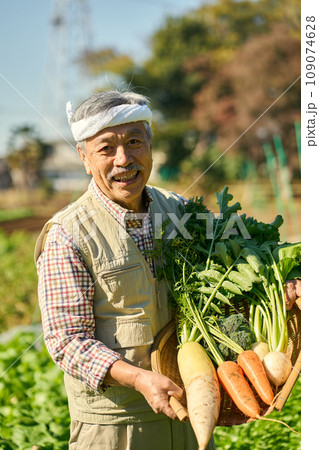 農作物を抱える農家の男性 109074628