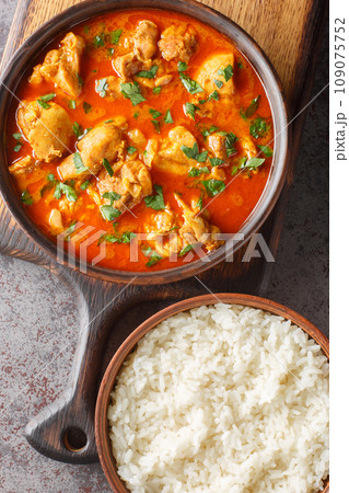 Lahori Chicken an Indian chicken curry dish from Pakistan served over basmati rice closeup on the wooden board. Vertical top view 109075752