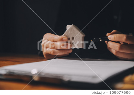 Real estate agent and customer signing contract to buy house, insurance or loan real estate.rent a house,get insurance or loan real estate or property. 109077600