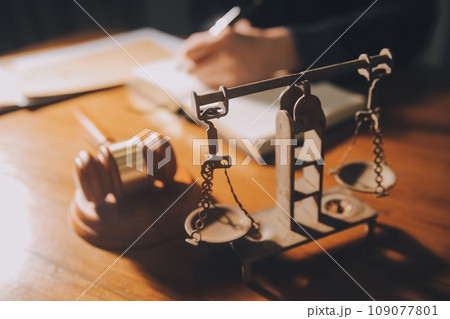 law books and scales of justice on desk in library of law firm. jurisprudence legal education concept. 109077801