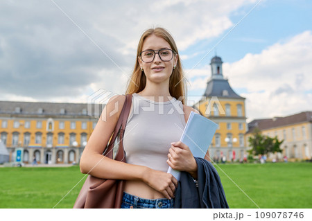 Young girl student posing outdoors, background of educational building 109078746