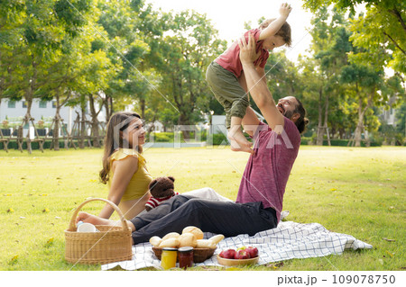 Happy family picnic in the park public on summer holiday.  Family relax and enjoying outdoor 109078750
