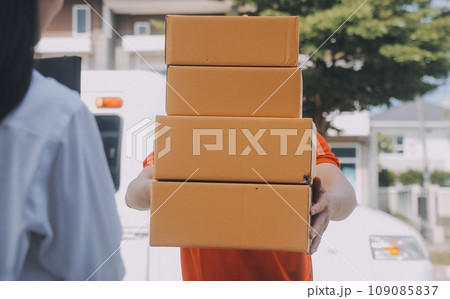 Asian Woman Receiving Product from delivery man at Home, Young Owner Woman Order Product from Smartphone Application, Woman with Online Business or SME Concept. Asian Woman Receiving Product from delivery man at Home, Young Owner Woman Order Product from Smartphone Application, Woman with Online Business or SME Concept. 109085837