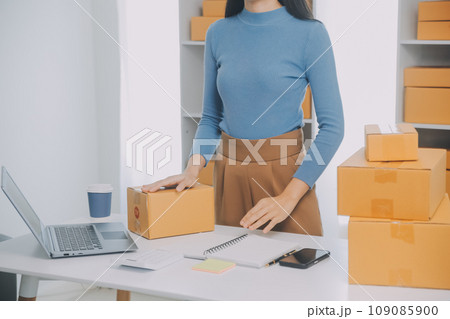 Business woman start up small business entrepreneur SME success .freelance woman working at home with Online Parcel delivery. SME and packaging deliveryconcept 109085900