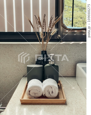 Two hand towels  in the bathroom with liquid soap dispenser on bamboo tray 109088275