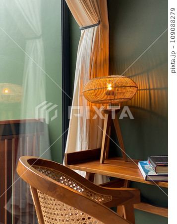 Table lamp with rattan shade on wooden table 109088279