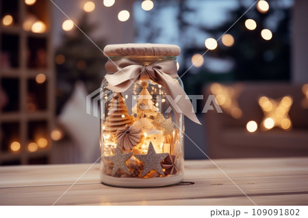 Christmas decoration with a light in a jar on wooden table. Christmas decoration with a light in a jar on wooden table. 109091802