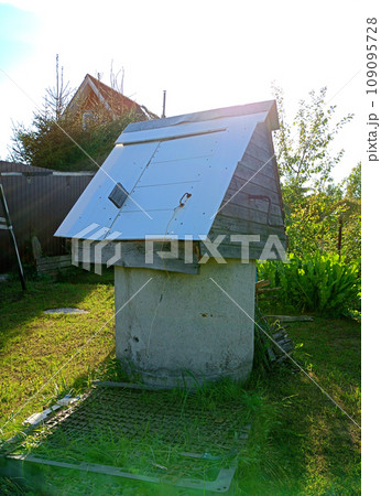 A round stone well for water extraction with a wooden roof 109095728