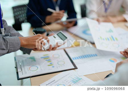 Two business people meeting to talking or discuss marketing work in workplace using paperwork, calculator, computer to work. 109096068
