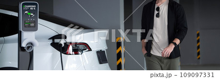 Young man travel with EV electric car to shopping center parking lot innards Young man travel with EV electric car to shopping center parking lot innards 109097331