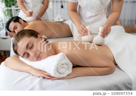 Hot herbal ball spa massage body treatment at day spa . Quiescent 109097354