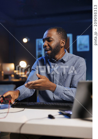 African american technology internet star filming review of newly released USB wired , mouse , giving audience feedback about comfort experience, doing endorsement for sponsoring brand 109098313