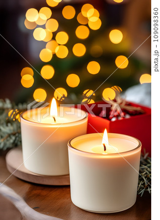 The warm glow of two wax candles on a table, evoking memories of christmas and creating a cozy ambiance 109098360