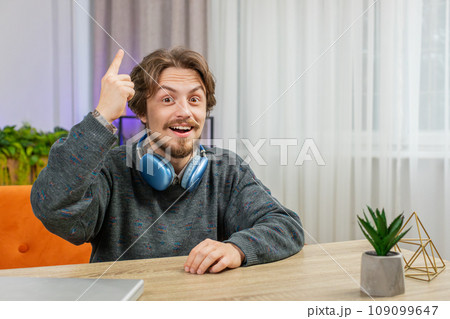 Thoughtful inspired Caucasian man make Eureka gesture raises finger came up creative plan at home 109099647