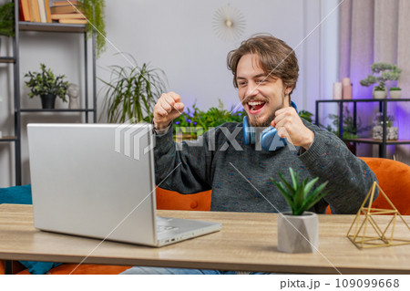 Amazed Caucasian man use laptop computer, receive good news message shocked by victory celebrate win Amazed Caucasian man use laptop computer, receive good news message shocked by victory celebrate win 109099668