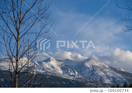 爽快な青空と冠雪した美瑛岳・美瑛富士・十勝岳方面の風景｜北海道美瑛町 109100734