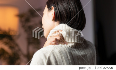部屋で肩を押さえる女性 109102556