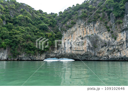 ベトナム　奇岩が続くハロン湾でカヤックを漕いで観光ポイントの穴に着いた人 109102646