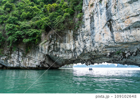 ベトナム　奇岩が続くハロン湾でカヤックを漕いで観光ポイントの穴に着いた人 109102648