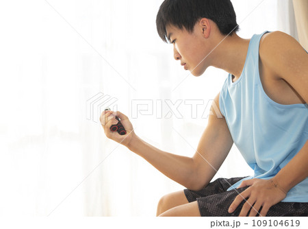 ハンドグリップで握力を鍛える10代の男性 ハンドグリップで握力を鍛える10代の男性 109104619